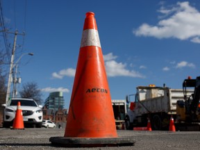 Aecon Group Inc. signage is displayed on a traffic safety cone at a construction site in Toronto, Ontario.