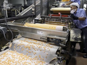 FILE - In this Jan. 14, 2009 file photo, Sweethearts candy drop onto a conveyor belt as they are manufactured at the New England Confectionery Company in Revere, Mass. Four bidders are vying to buy the bankrupt manufacturer of Necco Wafers, Sweethearts and other iconic candies. A bankruptcy auction is scheduled for Wednesday, May 23, 2018.