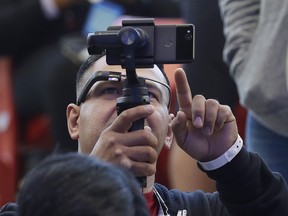 Developer Jesus Suarez wears Google Glass glasses while looking at his phone before the start of the keynote address at the Google I/O conference in Mountain View, Calif., Tuesday, May 8, 2018.