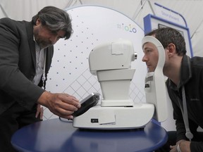Jorge Cuadros, left, gives a demonstration of a robotic retinal camera to a reporter at the Google I/O conference in Mountain View, Calif., Tuesday, May 8, 2018. Earlier this week, Google unveiled demos of new A.I. services that had the web abuzz, including Duplex, which would allow users to outsource the drudgery of booking appointments with businesses by phone to a virtual personal assistant.