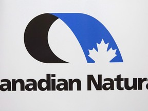 Canadian Natural Resources logo is shown at the company's annual meeting in Calgary on May 4, 2017. Canadian Natural Resources Ltd. says it choked back heavy oil production by about 17,000 barrels per day in the first quarter to deal with low prices it blames on poor pipeline capacity out of Western Canada.