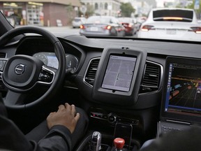 In this Dec. 13, 2016 file photo, an Uber driverless car waits in traffic during a test drive in San Francisco. Uber Technologies Inc. says it is "doubling down" on its self-driving efforts in Toronto more than two months after a woman was struck and killed by one of its vehicles.