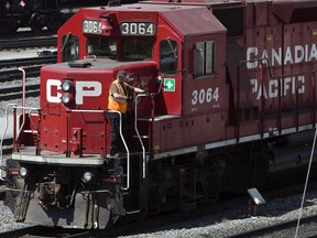 A Canadian Pacific Railway employee walks along the side of a locomotive in a marshalling yard in Calgary.