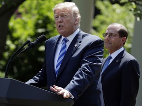 President Donald Trump speaks during an event about prescription drug prices with Health and Human Services Secretary Alex Azar, right, in the Rose Garden of the White House, Friday May 11, 2018, in Washington