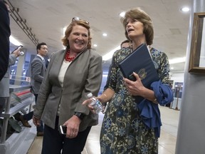 Sen. Heidi Heitkamp, D-N.D., left, and Sen. Lisa Murkowski, R-Alaska, arrive to vote on a bill to expand private care for military veterans as an alternative to the troubled Veterans Affairs health system, on Capitol Hill in Washington, Wednesday, May 23, 2018.