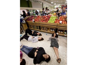 Demonstrators lie on the floor at a Publix Supermarket in Coral Springs, Fla., Friday, May 25, 2018. Students from the Florida high school where 17 people were shot and killed earlier this year did a "die in" protest at a supermarket chain that backs a gubernatorial candidate allied with the National Rifle Association. Shortly before the the "die-in" Publix  announced that it will suspend political donations.