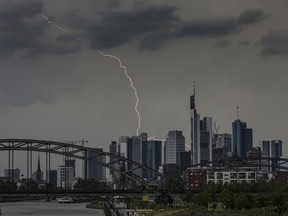In this May 22, 2018 photo a thunderbolt goes down behind the banking district in Frankfurt, Germany.