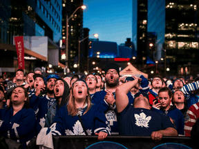 Fans at Maple Leaf Square in Toronto cheer their team.