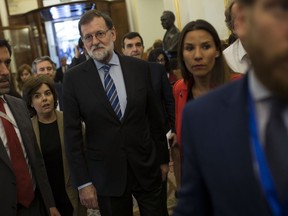 Spain's Prime Minister Mariano Rajoy, centre, arrives to the main chamber during the national budget debate at the Spanish parliament in Madrid, Wednesday, May 23, 2018. Spain's parliament is set to pass the national budget proposal for 2018, giving the government of Prime Minister Mariano Rajoy some breathing space as it battles Catalan separatism.