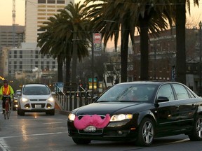 FILE - In this Jan. 17, 2013, file photo, a Lyft car crosses Market Street in San Francisco. In a big win for labor advocates, the California Supreme Court has limited the ability of businesses to classify workers as independent contractors, which could affect a range of workers in the so-called "sharing economy," such as Uber and Lyft drivers.