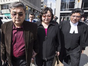 File - In this April 11, 2017 file photo, Akhmet Tokbergenov, left, and Dinara Tokbergenova, parents of alleged Yahoo hacker Karim Baratov, leave the court after their son was denied bail, with lawyer Deepak Paradkar, right, in Hamilton, Ont. A Canadian computer hacker was sentenced to five years in prison in connection with a massive security breach at Yahoo that federal agents say was directed by Russian government spies. U.S. Judge Vince Chhabria also on Tuesday, May 29, 2018, fined Karim Baratov $250,000.