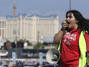 File - In this May 22, 2018 file photo, volunteer Jenifer Murias yells into a megaphone as Culinary Union members file into a university arena to vote on whether to authorize a strike in Las Vegas. The union representing thousands of Las Vegas casino workers says the two largest operators would lose more than $10 million a day combined if housekeepers, cooks and others go on strike. The Culinary Union on Wednesday, May 30, 2018, released documents explaining how it thinks a one-month strike would impact MGM Resorts International and Caesars Entertainment.