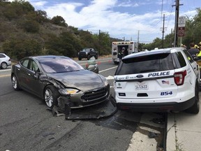 This photo provided by the Laguna Beach Police Department shows a Tesla sedan, left, in autopilot mode that crashed into a parked police cruiser Tuesday, May 29, 2018, in Laguna Beach, Calif. Police Sgt. Jim Cota says the officer was not in the cruiser at the time of the crash and that the Tesla driver suffered minor injuries. (Laguna Beach Police Department via AP)