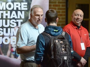 FILE - In this March 14, 2018 file photo, Dan Cieslak, left, a Human Resources representative for the Dunham's Distribution Center, and Warren Whitlow, a training manager, speak to students and other visitors during the Experience Indiana job fair event in the student center at Indiana Wesleyan University in Marion, Ind. U.S. employers advertised 6.6 million open jobs in March, the most on records dating back to December 2000, suggesting businesses want to staff up to meet strong demand. Job openings rose 7.8 percent in March from 6.1 million in February, the Labor Department said Tuesday, May 8.  Yet overall hiring slipped, while quits increased.
