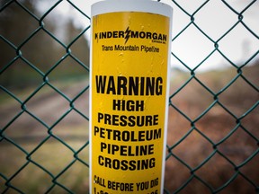 A sign warning of an underground petroleum pipeline is seen on a fence at Kinder Morgan's facility in Burnaby, B.C. There is just a week remaining until the deadline set for abandoning the Trans Mountain pipeline expansion.