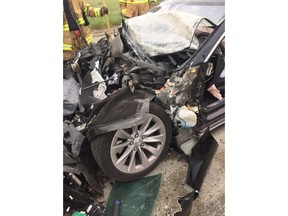 In this Friday, May 11, 2018, photo released by the South Jordan Police Department shows a traffic collision involving a Tesla Model S sedan with a Fire Department mechanic truck stopped at a red light in South Jordan, Utah. Witnesses indicated the Tesla Model S did not brake prior to impact. Police Sgt. Samuel Winkler said the car's air bags were activated and that the Tesla's 28-year-old driver suffered a broken right ankle, while the driver of the mechanic truck didn't require treatment. Police in a Salt Lake City suburb say it's not immediately known whether a Tesla Model S sedan's semi-autonomous Autopilot driving system was in use when it rear-ended a truck apparently without braking before impact at approximately 60 mph. (South Jordan Police Department via AP)