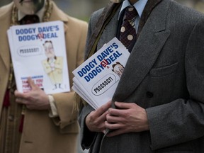 FILE - In this Feb. 19, 2016 file photo, representatives of Leave.EU, a group that campaigns against Britain's membership in the European Union, hold pamphlets as they pose for photographs in London. Britain's electoral watchdog said on Friday, May 11, 2018, that it fined Leave.EU and referred its chief executive to police for breaking spending rules during the 2016 EU membership referendum.