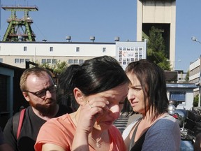 FILE - In this Saturday, May 5, 2018 file photo, a woman cries in front of the Zofiowka coal mine after miners were reported missing following a powerful tremor at the mine, in Jastrzebie-Zdroj in southern Poland. Officials in Poland have said on Sunday, May 13 that they have recovered the bodies of two miners killed when an earthquake hit a coal mine in southern Poland last week, bringing the death toll to four. The Jastrzebie Coal Company says that the two have been found after many days of rescue efforts.