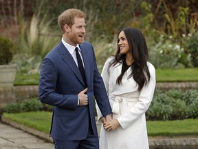 FILE - In this file photo dated Monday Nov. 27, 2017, Britain's Prince Harry and fiancee Meghan Markle pose for photographers during a photocall in the grounds of Kensington Palace in London, marking the couple's engagement to marry.  Now with only a week until the May 19 wedding of Prince Harry and Meghan Markle, a party atmosphere is developing in the English city of Windsor, with tens of thousands of visitors expected in the city on the couple's wedding day.