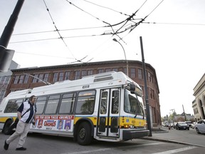 In this Wednesday, May 2, 2018 photo a passenger walks toward a bus powered by electricity supplied through overhead wires, in Watertown, Mass. According to a report released by Massachusetts Public Interest Research Group, or MASSPIRG, Thursday, May 3, 2018, cities and states across the U.S. should move toward replacing their old, diesel-fueled bus fleets with battery electric-powered buses as another step toward weaning the country off fossil fuels. A MASSPIRG spokesman said Thursday that buses with overhead electrical wires are great where the infrastructure is set up for them.