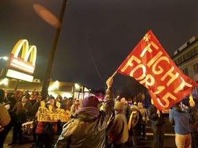 FILE - In this Nov. 29, 2016 file photo, protesters gather outside a McDonald's restaurant in Minneapolis during a demonstration for higher wages as part of the National Day of Action to Fight for $15. On Tuesday, May 22, 2018, Fight for $15 is announcing that it's helping women in several U.S. cities to file complaints with the U.S. Equal Employment Opportunity Commission alleged they experienced sexual harassment while working at McDonald's.
