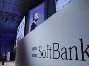 FILE - In this July 20, 2017, file photo, SoftBank Group Corp. Chief Executive Officer Masayoshi Son, left, speaks during a SoftBank World presentation at a hotel in Tokyo.  SoftBank will spend $2.25 billion for a nearly a 20 percent stake in General Motors' autonomous vehicle unit. GM said Thursday, May 31, 2018, that it will also sink another $1.1 billion into Cruise Automation. The capital infusion is designed to speed large-scale deployment of self-driving robotaxis next year.