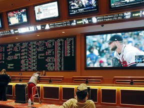 FILE - In this Monday, May 14, 2018 file photo, people make bets in the sports book area of the South Point Hotel and Casino in Las Vegas. Those who deal with compulsive gambling are worried that a rapid expansion of sports betting in the U.S. could cause more people to develop gambling problems. The U.S. Supreme Court on Monday cleared the way for states to legalize sports betting.