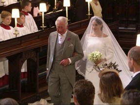 In this frame from video, Meghan Markle walks down the aisle with Prince Charles for her wedding ceremony at St. George's Chapel in Windsor Castle in Windsor, near London, England, Saturday, May 19, 2018.  (UK Pool/Sky News via AP)