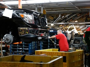 FILE- In this March 19, 2018, file photo, a technician tightens screws on the front bumper assembly at the Nissan Canton Assembly Plant, in Canton, Miss. On Tuesday, May 1, the Institute for Supply Management, a trade group of purchasing managers, issues its index of manufacturing activity for April.