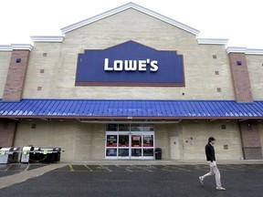FILE- In this Feb. 23, 2018, file photo a passer-by walks near an entrance to a Lowe's retail home improvement and appliance store, in Framingham, Mass. Lowe's Companies Inc. reports earnings on Wednesday, May 23.