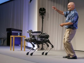 FILE - In this July 20, 2017 file photo, Boston Dynamics Chief Executive Marc Raibert speaks about his four-legged robot SpotMini during a SoftBank World presentation at a hotel in Tokyo. The robotics company known for its widely shared YouTube videos of nimble, legged robots opening doors or walking through rough terrain is finally preparing to sell some of them after years of research. Raibert said Friday, May 11, 2018, his company will begin selling the dog-like SpotMini robot next year, likely to businesses for use as a camera-equipped security guard.  He made the announcement at a TechCrunch robotics conference at University of California, Berkeley.