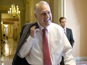 FILE - In this Dec. 30, 2012, file photo, Senate Minority Whip Jon Kyl, R-Ariz., walks between the Senate chamber and the office of Senate Minority Leader Mitch McConnell, R-Ky., in Washington. Facebook has enlisted two outside advisers to examine how it treats underrepresented communities and whether it has a liberal bias. Former Sen. Jon Kyl, an Arizona Republican, will examine concerns about a liberal bias on Facebook. Civil rights leader Laura Murphy will examine civil rights issues, along with law firm Relman, Dane & Colfax.