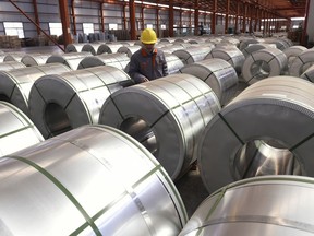FILE - In this April 7, 2018, file photo, a worker checks on rolls of aluminum at a factory in Zouping county in east China's Shandong province. Small businesses are threatened by higher costs from U.S. steel and aluminum tariffs and by a broader trade fight with China, as steel costs are already higher since the Trump administration announced a 25 percent tariff on the metal in March. (Chinatopix via AP, File)