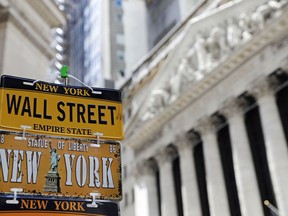 FILE- In this April 26, 2018, file photo, a sample of license plates for sale at a souvenir stand are shown in front of the New York Stock Exchange on Wall Street in the Financial District. The U.S. stock market opens at 9:30 a.m. EDT on Friday, May 18.