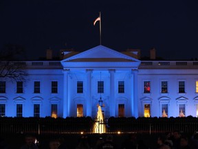 FILE - In this April 2, 2017, file photo, the White House is lit with blue lights in honor of World Autism Awareness Day in Washington. Top U.S. tech executives and researchers are gathering at a White House summit, Thursday, May 10, 2018, to press Trump administration officials on investing in artificial intelligence and crafting policies they hope will strengthen the economy without displacing jobs.