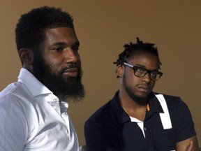 FILE – In this April 18, 2018, file photo, Rashon Nelson, left, and Donte Robinson, right, both 23, listen to a reporter's question during an interview with The Associated Press in Philadelphia. The two black men, arrested for sitting at a Starbucks cafe in Philadelphia without ordering anything, settled with the city of Philadelphia for a symbolic $1 each Wednesday, May 2, 2018, and a promise from city officials to set up a $200,000 program for young entrepreneurs.