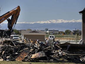 FILE - In this May 4, 2017, file photo, workers dismantle the charred remains of a house where an explosion killed two people in Firestone, Colo. A shareholder lawsuit alleges Anadarko Petroleum was focused on keeping old wells running, not fixing potential safety problems in the months before the fatal house explosion.