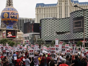 FILE--In this March 20, 2013, file photo, Culinary Union workers demonstrate along Las Vegas Boulevard outside the Cosmopolitan Hotel and Casino while protesting their contract negotiations with Deutsche Bank in Las Vegas. The union representing thousands of Las Vegas casino workers estimates that the two largest resort operators would lose more than $10 million a day combined if housekeepers, cooks and others go on strike at any time starting Friday, June 1, 2018.