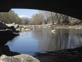 In this April 25, 2018 photo, the Arkansas River flows under a bridge in Salida, Colo., with the snow-covered Sawatch Range mountains in the background. Despite a severe drought across the Southwestern United States, there should be plenty of water this year for rafters and anglers in the Arkansas, one of the nation's most popular mountain rivers. State and federal officials say water from melting snow will surge down the river thanks to a surprisingly wet winter in the towering peaks of the Sawatch Range where the river begins.
