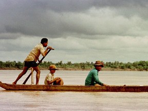 FILE - In this Nov. 3, 1996, file photo, villagers ride a dugout up the Mekong River near Sambor, Cambodia where a major dam has been proposed. A study says a Chinese-backed plan for Cambodia to build the Mekong River's biggest dam would destroy fisheries that feed millions and worsen tensions with Vietnam, the downstream country with most to lose from dams on the waterway.