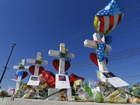 In this photo taken Saturday, April 28, 2018, in Nashville, Tenn., crosses are seen as a memorial outside the Waffle House where four people were shot and killed. At 3:25 a.m. on April 22, a Waffle House in suburban Nashville joined the growing list of cherished American places morphed into the site of a massacre.