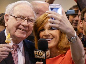 Warren Buffett, holds an ice cream bar as he poses for a selfie with Liz Claman of the Fox Business Network, at last year’s shareholders meeting.