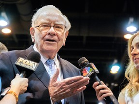Warren Buffett, Chairman and CEO of Berkshire Hathaway, speaks to reporters during a tour of the exhibit floor at the shareholders’ meeting in Omaha, Neb., Saturday.
