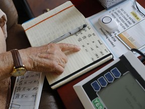 In this May 29, 2018, photo, Sidney Kramer, 92, points to his notebook he uses to help him keep track of vital signs after using a remote medical monitoring system at his home in Bethesda, Md. A new poll shows older Americans and their caregivers want to give virtual health care a try, even though Medicare has been slow to pay. Nearly 9 in 10 would be comfortable using at least one type of telemedicine for themselves or an aging loved one.