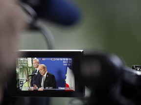 France's Finance Minister Bruno Le Maire, left, and Foreign Minister Jean-Yves Le Drian deliver their statement, pictured on a video viewer screen, at Bercy ministry, in Paris, Tuesday, May 15, 2018. Le Maire and Le Drian said they are determined to preserve the interests of French companies which have invested in Iran, following U.S. decision to withdraw from the Iran nuclear agreement and to impose tough economic sanctions on the country.
