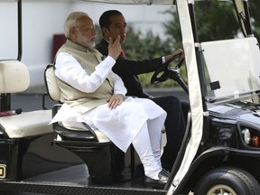 Indian Prime Minister Narendra Modi, left, rides on a golf cart driven by Indonesian President Joko Widodo during their meeting at Merdeka Palace in Jakarta, Indonesia, Wednesday, May 30, 2018.
