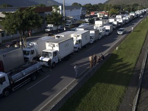 Truckers stand on a partially blocked road that connects the cities Rio de Janeiro and Teresopolis, to protest diesel price hikes, in Guapimirim, Brazil, Wednesday, May 23, 2018. Diesel prices have been steadily rising over the last year as world oil prices have gone up and the Brazilian real has devalued sharply against the U.S. dollar.