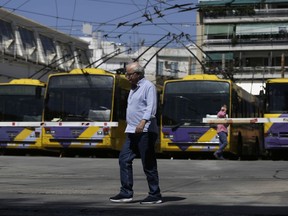 A man walks past parked electric trolley buses in a depot during a 24-hours public transport strike, in Athens, on Thursday, May 31, 2018. Transport workers walked off the job a day after a nationwide general strike to protest against plans to extend austerity measures.