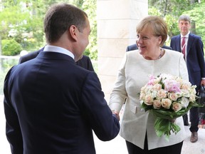 Russian Prime Minister Dmitry Medvedev, left, greets German Chancellor Angela Merkel during their meeting at Putin's residence in the Russian Black Sea resort of Sochi, Russia, Friday, May 18, 2018. The meeting in Sochi is Merkel's first visit to Russia in a year and comes amid tense relations between Berlin and Moscow.
