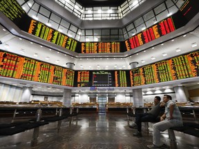 Investors watch trading boards at a private stock market gallery in Kuala Lumpur, Malaysia, Monday, May 14, 2018. New Malaysian Prime Minister Mahathir Mohamad said a special five-member council would be set up to advise the government on economic and financial matters. The council will include Hong Kong-based tycoon Robert Kuok, Malaysia's richest man, he said.